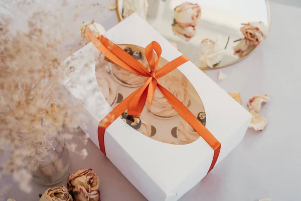 Gift box with blueberry cupcake cakes, white box with red ribbon, delicate gift