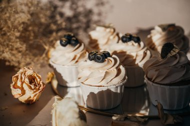 Yuvarlak altın aynadaki kekler, bej kompozisyon, kuru çiçekler.