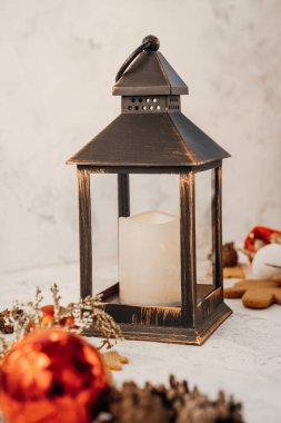 İçinde mum olan bir Noel ışığı, arka planda Noel ağacı süslemeleri, beyaz arka plan.