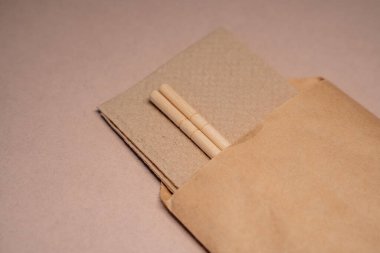 Çin çubuklarının bej arka planda el işi kağıt ambalajlarıyla yakın plan çekimleri