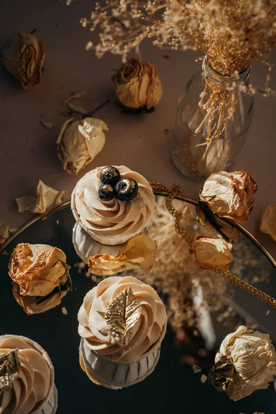 Blueberry cupcakes in the setting rays of the sun, hard light and shadows, dried flowers