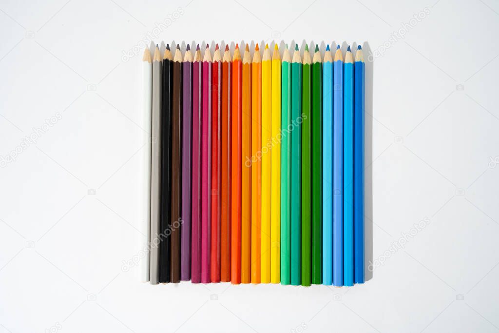 Rainbow colored pencils lie on white isolated background, collection