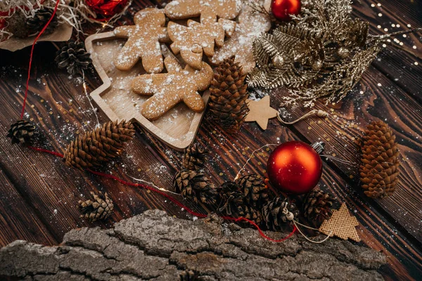 Noel arkaplanı zencefilli kurabiyelerle süslenmiş tarçınlı ve köknar kozalaklı, tebrik kartı.