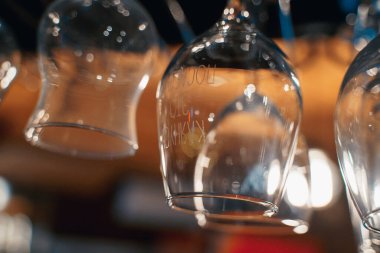 Gece kulübündeki bir barda ters çevrilmiş şeffaf şarap kadehlerinin yakın çekimi.