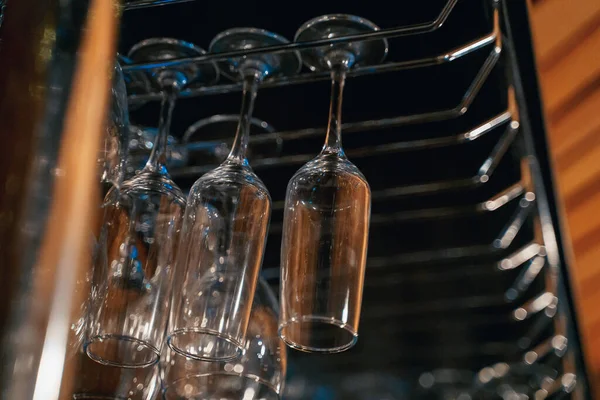 Vasos transparentes para bebidas cuelgan en el bar, vida nocturna, orden — Foto de Stock