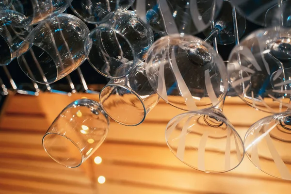 Gece kulübündeki bir barda ters çevrilmiş şeffaf şarap kadehlerinin yakın çekimi.