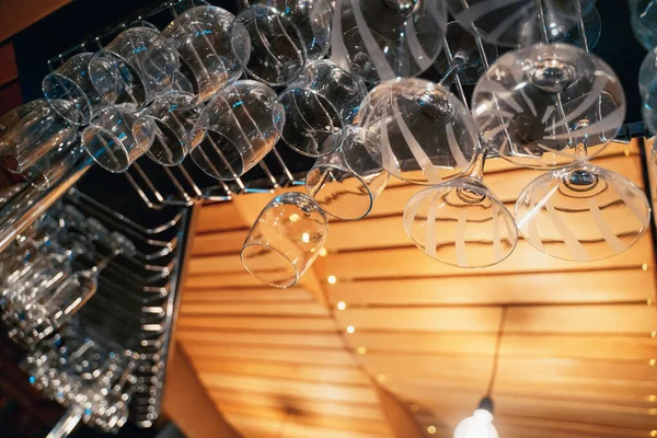 Vasos transparentes para bebidas cuelgan en el bar, vida nocturna, orden — Foto de Stock