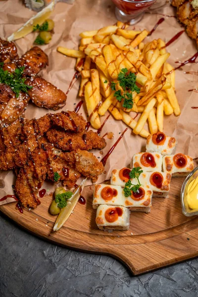 Kombinasyon seti, yakın plan, patates kızartması, suşi, rulo, fırında tavuk ve ahşap tepside sos.