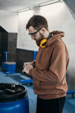 Adam hedefe ateş etmeden önce silahını dolduruyor. Tabanca şarjörünü dolduruyorum. Spor eğlencesi