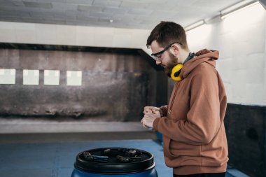 Adam hedefe ateş etmeden önce silahını dolduruyor. Tabanca şarjörünü dolduruyorum. Spor eğlencesi