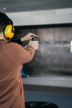 Bir adam atış poligonunda bir hedefe ateş ediyor. Spor eğlencesi. Hedefi vuruyorum.