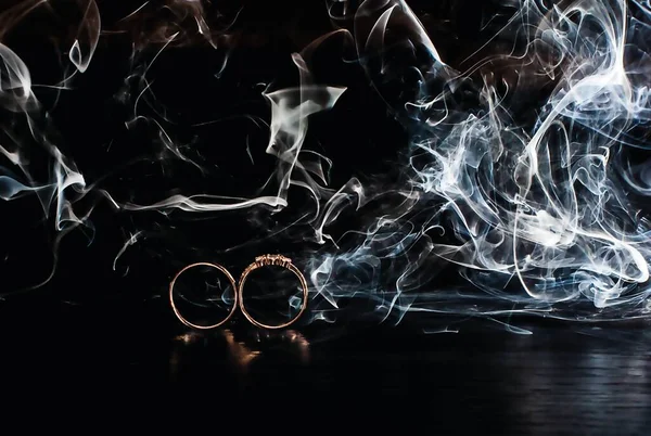 Two rings in the dark on a background of smoke, wedding details