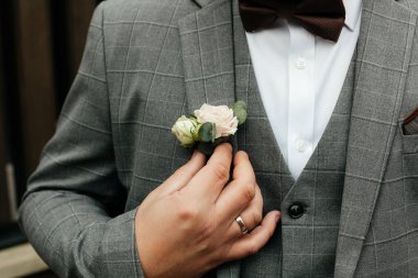 Papyonlu damat takım elbisesinin yaka çiçeğini, evlilik törenini, düğün konseptini ayarlar.