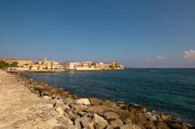 Siracusa sahili ve Ortigia adası manzaralı eski kasaba binaları güneşli yaz günlerinde evleri ve kiliseleri taşlaştırıyor. Turistik kitapçık ya da kitap için parlak renkli bir fotoğraf, tekne gezisi reklamları, posterler vs..
