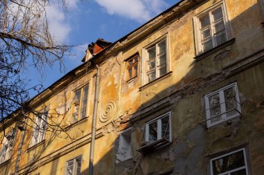 Pencereleri ve balkonları olan sarı kahverengi bir binanın ön cephesi. Odessa Ukrayna 'nın eski şehir merkezinde tipik bir yarı yıkılmış ev. Parlak güneşli bahar fotoğrafı.