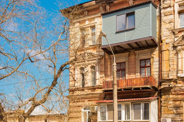 Odessa, Ukrayna - 04: 21: Pencereleri, balkonları ve antik heykelleri olan sarı barok tarzı bir bina cephesi. Odessa tarihi şehir merkezinde mimari detayı. Parlak güneşli bahar fotoğrafı.