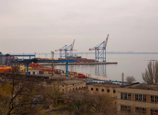 Odessa, Ukraine - 04 19 21: Containers, boats cranes and other industrial constructions in port docks. Gray rainy foggy gloomy weather early spring photo — стокове фото