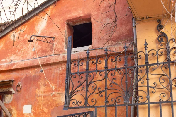 An architectural element of old building facade of typical houses in Odessa old town city center. Forged lattice, dirty scratched orange yellow walls. Background photo with free copy space for text — Fotografia de Stock