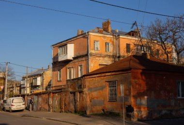 Odessa, Ukrayna - 04: 22: 21: Ukrayna 'nın eski Moldovanka ilçesinde güneşli bir bahar akşamı. Eski harap evler, yapraksız ağaçlar, sıcak sarı güneş ışığı..