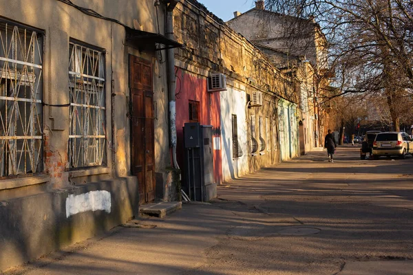 Odessa, Ucrania - 04 22 21: Soleado atardecer de primavera en el antiguo distrito de Moldovanka de Odessa, Ucrania. Antiguas casas en ruinas, árboles sin hojas, cálida luz amarilla del sol. —  Fotos de Stock