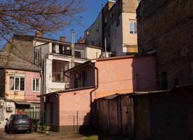 Odessa, Ukraine - 04 22 21: A classic old town courtyard. Bright sunny spring atmospheric photo with vintage yard, multi level houses, dirty scratched walls