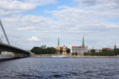 Letonya Kalesi 'nin yeniden inşa edilişinin Riverside manzarası. Fotoğraf, bulutlu bir gökyüzü ile sıcak bir yaz gününde çekildi..