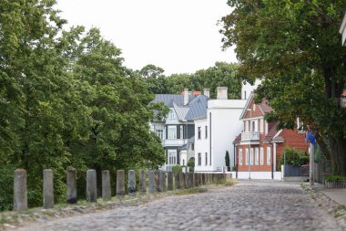 Eşsiz eski ve yeni mimari evleri olan eski tuğla sokak. Fotoğraf Riga, Letonya 'da, sıcak ve bulutlu bir günde çekildi..