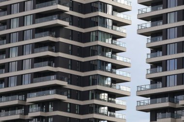 Eşsiz stil yeni çağ, birçok balkonu olan modern mimari binalar. Fotoğraf, arka planda bulutlu gökyüzü ile sıcak bir yaz gününde çekildi..