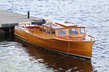 İskelenin yakınındaki klasik ahşap tekne. Fotoğraf, sıcak bir yaz bulutlu bir günde çekildi..