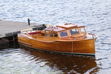 İskelenin yakınındaki klasik ahşap tekne. Fotoğraf, sıcak bir yaz bulutlu bir günde çekildi..