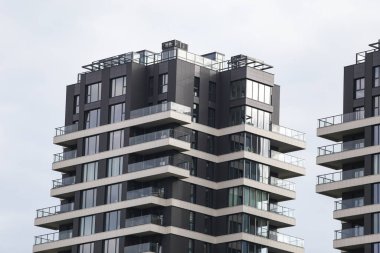 Eşsiz stil yeni çağ, birçok balkonu olan modern mimari binalar. Fotoğraf, arka planda bulutlu gökyüzü ile sıcak bir yaz gününde çekildi..