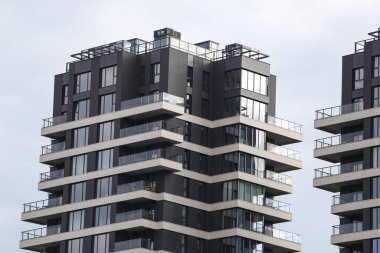 Eşsiz stil yeni çağ, birçok balkonu olan modern mimari binalar. Fotoğraf, arka planda bulutlu gökyüzü ile sıcak bir yaz gününde çekildi..