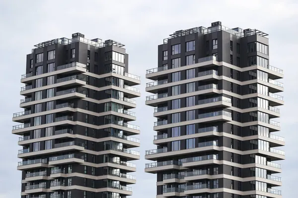 Eşsiz stil yeni çağ, birçok balkonu olan modern mimari binalar. Fotoğraf, arka planda bulutlu gökyüzü ile sıcak bir yaz gününde çekildi..