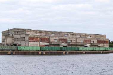 Tren rayları ve yük treni olan eski tuğla bina.