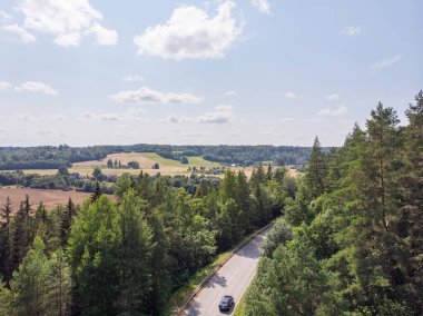 Tek arabalı otobanın gerçek bir insansız hava aracı görüntüsü. Yolun iki tarafında da orman var..
