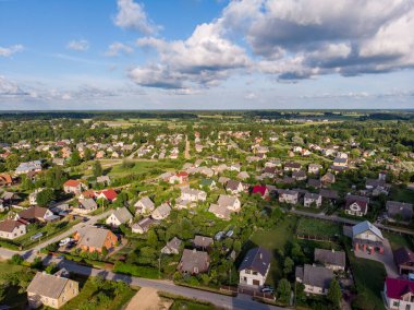 Küçük şehir banliyölerinin, evlerin ve sokakların gerçek insansız hava aracı görüntüsü. Fotoğraf, güneşli bir yaz gününde çekildi..
