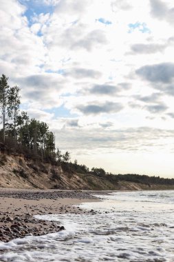 Baltık Denizi yakınında kıyı şeridi olan doğa manzarası. Fotoğraf rüzgarlı ve bulutlu bir günde çekildi..
