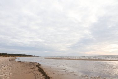 Kum ve Baltık Denizi ile güzel deniz manzarası. Fotoğraf, sıcak ve bulutlu bir sonbahar havasında çekildi..