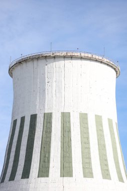 Büyük beyaz termik santral bacasının yakın çekimleri. Fotoğraf mavi bulutlu gökyüzünün önünde çekildi.