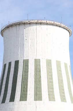 Büyük beyaz termik santral bacasının yakın çekimleri. Fotoğraf mavi bulutlu gökyüzünün önünde çekildi.