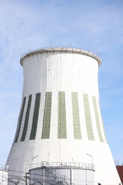 Büyük beyaz termik santral bacasının yakın çekimleri. Fotoğraf mavi bulutlu gökyüzünün önünde çekildi.