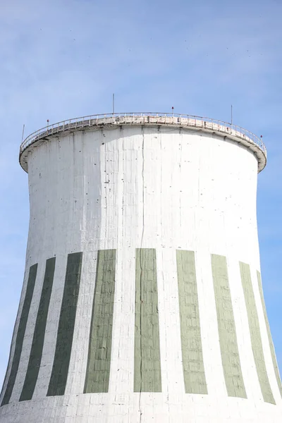 Büyük beyaz termik santral bacasının yakın çekimleri. Fotoğraf mavi bulutlu gökyüzünün önünde çekildi.