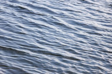 Close-up water reflection texture, pattern, with small waves. Photo taken in daylight.