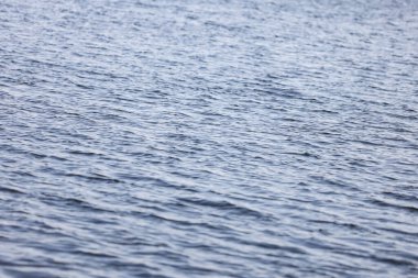 Close-up water reflection texture, pattern, with small waves. Photo taken in daylight.