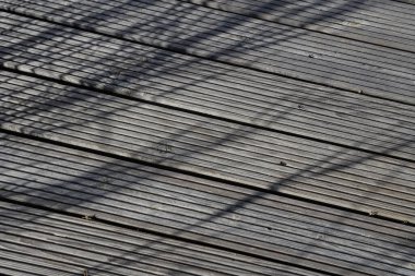 Yürüyen patikaların deniz çimi gölgeleriyle çekilmiş yakın plan ahşap fotoğrafı. Fotoğraf sıcak, bulutlu bir sonbahar gününde çekildi..