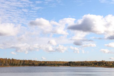 Bulutlu bulutlu sonbahar manzaralı, küçük bir nehir ve bulutlu bir gökyüzü. Fotoğraf Ekim 'de çekildi.