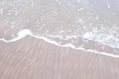 Deniz kıyısı manzaralı küçük dalga baloncukları. Fotoğraf, sıcak bir bulutlu günde çekildi..