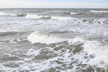 Orta ölçekli baltık deniz dalgaları beyaz kabarcıklar. Fotoğraf sıcak, bulutlu bir sonbahar gününde çekildi..