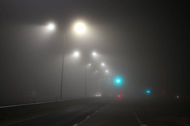 Trafik ışıkları ve otoyolun puslu manzarası. Fotoğraf ılık bir bahar gününde çekildi..