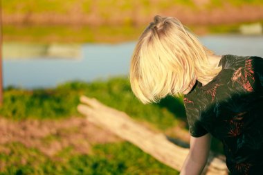 Çiftlikteki uzun sarı saçlı çocuğun portresi.